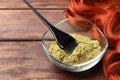 Bowl of henna powder, brush and red strand on wooden table, space for text. Natural hair coloring Royalty Free Stock Photo