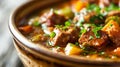 Bowl of home cooked delicious one-pot beef stew with potatoes carrots onions garlic pees and herbs braised in wine. Comfort food