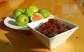 Bowl of homemade fig jam with Blurry green fresh ripe figs in background Royalty Free Stock Photo