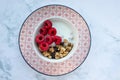 Bowl of homemade granola cereal with greek yogurt and fresh raspberry berries on white marble table background. Top view Royalty Free Stock Photo