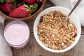 A bowl of homemade granola with yogurt and fresh strawberries on a wooden background. Healthy breakfast Royalty Free Stock Photo