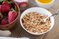 A bowl of homemade granola with yogurt and fresh strawberries on a wooden background. Healthy breakfast with green tea Royalty Free Stock Photo