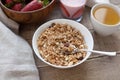 A bowl of homemade granola with yogurt and fresh strawberries on a wooden background. Healthy breakfast with green tea Royalty Free Stock Photo