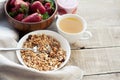 A bowl of homemade granola with yogurt and fresh strawberries on a wooden background. Healthy breakfast with green tea Royalty Free Stock Photo