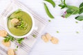 Bowl of homemade green spring pea soup topped with pumpkin seeds, croutons. On white background. flat lay. Royalty Free Stock Photo