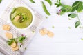 Bowl of homemade green spring pea soup topped with pumpkin seeds, croutons. On white background.flat lay. Royalty Free Stock Photo