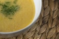 Bowl of homemade lentil soup in a white soup bowl with fresh green dills, close up