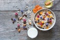 Bowl of homemade muesli with nuts, berries, dried fruits, glass of milk and honey Royalty Free Stock Photo