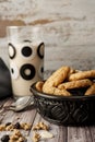 Bowl with homemade oatmeal cookies with raisins and seeds and a glass of milk behind. Portrait orientation. Natural nutrition