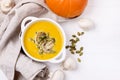 Bowl of Homemade Pumpkin and Mushrooms Soup with Cream and Pumpkin Seeds on Linen Napkin White Wooden Background Top View Copy Royalty Free Stock Photo