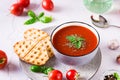 Bowl with homemade tomato soup with basil and fresh vegetables on the table Royalty Free Stock Photo