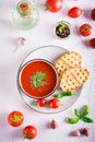 Bowl with homemade tomato soup with basil and fresh vegetables on the table. Top and vertical view Royalty Free Stock Photo