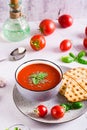 Bowl with homemade tomato soup with basil and fresh vegetables on the table. Vertical view Royalty Free Stock Photo