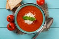 Bowl of homemade tomato soup over turquoise wooden table. Italian hot soup puree of roasted tomatoes with parmesan and basil. Royalty Free Stock Photo