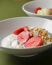 Bowl of hot oatmeal with fresh strawberries cut. Perfect as a healthy breakfast. Served with sour cream in a white bowl. Royalty Free Stock Photo