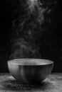 Bowl of hot steam of hot soup with smoke. black ceramic bowl on dark background. Hot food. Culinary, cooking, concept Royalty Free Stock Photo