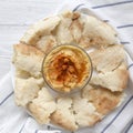 Bowl of Hummus with chickpeas, paprika, olive oil and pita bread on white plate over white wooden background, overhead view. From Royalty Free Stock Photo