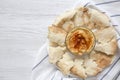 Bowl of Hummus with chickpeas, paprika, olive oil and pita bread on white plate over white wooden background, top view. From above Royalty Free Stock Photo