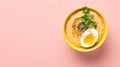 Bowl of hummus with greens on simple background