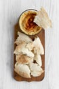 Bowl of Hummus with roasted chickpeas, paprika, olive oil and pita bread on rustic wooden board over white wooden background, top Royalty Free Stock Photo