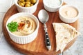 Bowl of hummus, traditional Jewish, Arabian, Middle Eastern food from chick-peas with deeps and with pita flatbread on ceramic