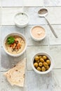 Bowl of hummus, traditional Jewish, Arabian, Middle Eastern food from chick-peas with deeps and with pita flatbread on ceramic