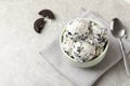 Bowl with ice cream and crumbled chocolate cookies on grey background