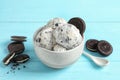 Bowl with ice cream and crumbled chocolate cookies on background