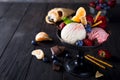 Bowl with ice cream with three different scoops of white, yellow, red colors and waffle cone, chocolate, tangerines and