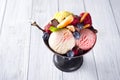 Bowl with ice cream with three different scoops of white, yellow, red colors and waffle cone, chocolate, tangerines and
