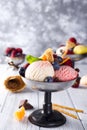 Bowl with ice cream with three different scoops of white, yellow, red colors and waffle cone, chocolate, tangerines and