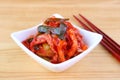 A Bowl of Iconic Korean Dish Kimchi, with a Pair of Chopsticks on Wooden Table