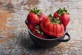 Bowl of imperfect ripe strawberries on rustic wooden background