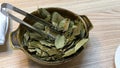 Bowl of Inca coca leaves on table restaurant in Cusco, Peru.