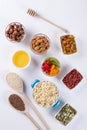 Bowl with ingredients for cooking homemade granola on white background. Healthy snak.