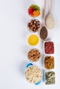 Bowl with ingredients for cooking homemade granola on white background. Healthy snak.