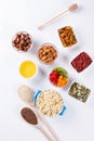 Bowl with ingredients for cooking homemade granola on white background. Healthy snak.