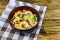 Bowl of instant Chinese noodles with shrimps, green onion and red hot chilli peppers on wooden table Royalty Free Stock Photo