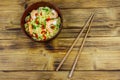 Bowl of instant Chinese noodles with shrimps, green onion and red hot chilli peppers on wooden table. Top view Royalty Free Stock Photo