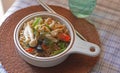 Bowl of instant noodles with parsley, mushrooms, chilli and basil in a in onion soup bowl over handmade coaster, Select Focus on Royalty Free Stock Photo