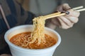 Bowl of instant noodles ramen in hands with chopsticks, close up Royalty Free Stock Photo