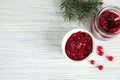 Bowl and jar with tasty cranberry sauce on white wooden background, flat lay Royalty Free Stock Photo