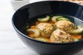 Bowl of Jewish matzoh balls soup on white wooden table Royalty Free Stock Photo