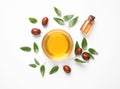 Bowl with jojoba oil and seeds on white background