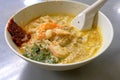 A bowl of laksa - a spicy noodle soup consisting of thick wheat noodles and seafood, popular in Southeast Asia.