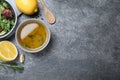 Bowl with lemon dressing near salad on grey table, flat lay with space for text. Delicious salad dressing Royalty Free Stock Photo