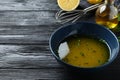 Bowl with lemon sauce on black wooden table, space for text. Delicious salad dressing Royalty Free Stock Photo