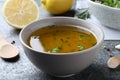 Bowl with lemon sauce on grey table, closeup. Delicious salad dressing Royalty Free Stock Photo