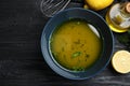 Bowl of lemon sauce and ingredients on black wooden table, flat lay. Delicious salad dressing Royalty Free Stock Photo