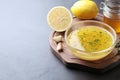 Bowl with lemon sauce and ingredients on dark table, space for text. Delicious salad dressing Royalty Free Stock Photo